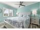 Comfortable bedroom with teal walls, large bed, ceiling fan and natural lighting at 912 N Shore Dr, Anna Maria, FL 34216
