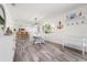 Open-concept dining area with a white dining table, modern light fixture, and coastal decor at 912 N Shore Dr, Anna Maria, FL 34216