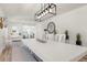 Dining area with a long white table, modern light fixture, and stylish decor at 912 N Shore Dr, Anna Maria, FL 34216