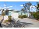 Side view of the home showing a garage with lush landscaping and long driveway at 912 N Shore Dr, Anna Maria, FL 34216