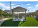 Charming gazebo provides a delightful outdoor seating area on a well-maintained artificial turf lawn at 912 N Shore Dr, Anna Maria, FL 34216