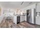Bright open kitchen with stainless steel appliances, white cabinets, grey backsplash and wood-look flooring at 912 N Shore Dr, Anna Maria, FL 34216