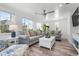 Bright living room with modern sofas, lots of windows, and a ceiling fan at 912 N Shore Dr, Anna Maria, FL 34216