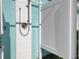 Close up of the outdoor shower with white privacy door attached to the light blue house at 912 N Shore Dr, Anna Maria, FL 34216