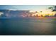 Beautiful water view as the sun sets over the ocean, casting orange and yellow hues on the clouds at 912 N Shore Dr, Anna Maria, FL 34216