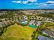 Aerial view of community amenities, showcasing the pool, tennis court, playground, and surrounding homes at 11330 80Th E St, Parrish, FL 34219