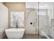 This bright bathroom boasts a soaking tub, frameless shower with bench and stunning marble accents at 1314 Brambling Ct, Bradenton, FL 34212