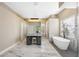 Modern bathroom featuring a soaking tub, marble floors, makeup vanity, and beautiful natural light at 1314 Brambling Ct, Bradenton, FL 34212