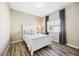 Cozy bedroom with wood-look floors, natural light from the window, and a white wooden bed frame at 1314 Brambling Ct, Bradenton, FL 34212