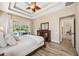 Main bedroom with tray ceiling, pool view, and dark wood furniture at 1314 Brambling Ct, Bradenton, FL 34212