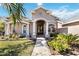 Inviting front entrance with arched doorway and beautifully landscaped yard at 1314 Brambling Ct, Bradenton, FL 34212