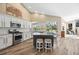 Bright kitchen features granite countertops, stainless steel appliances, island with bar seating, and wood-look tile flooring at 1314 Brambling Ct, Bradenton, FL 34212