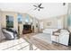 Bright living room with vaulted ceiling, large windows, modern furniture, wood-look flooring, and ceiling fan at 1314 Brambling Ct, Bradenton, FL 34212