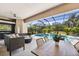 Inviting covered patio with stylish wicker furniture, fire pit, summer kitchen and a tranquil pool view at 1314 Brambling Ct, Bradenton, FL 34212
