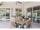 Covered outdoor dining space featuring a woven dining set, summer kitchen and serene poolside views at 1314 Brambling Ct, Bradenton, FL 34212