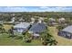 Aerial view of homes showcasing pool, screened lanai, and lake views in a lovely neighborhood at 1407 Morning Sky Gln, Bradenton, FL 34208