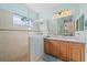 Bright bathroom features a double vanity, tiled walk-in shower with glass partition, and neutral color palette at 1407 Morning Sky Gln, Bradenton, FL 34208