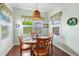 Dining area with wood floors, chandelier, and shuttered windows overlooking a pleasant landscape at 1407 Morning Sky Gln, Bradenton, FL 34208