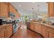 Spacious kitchen with warm wood cabinetry, stainless steel appliances, and granite countertops at 1407 Morning Sky Gln, Bradenton, FL 34208