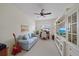 Cozy living room features a light blue sofa, ceiling fan and built-in shelving with a television at 1407 Morning Sky Gln, Bradenton, FL 34208