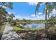 Scenic pond view from community walking path lined with tropical palm trees and lush native vegetation at 1407 Morning Sky Gln, Bradenton, FL 34208