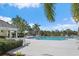 Community swimming pool surrounded by lounge chairs, umbrellas, tables, tropical plants, and a fence at 1407 Morning Sky Gln, Bradenton, FL 34208