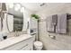 Modern bathroom featuring an oval mirror, granite countertops, white cabinets, and tiled walls at 1515 Forrest Nelson Blvd # Q205, Port Charlotte, FL 33952