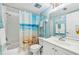 Bright bathroom with beach themed shower curtain and blue accents at 1515 Forrest Nelson Blvd # Q205, Port Charlotte, FL 33952