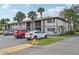 A well-maintained condo building with ample parking, mature palm trees, and lush landscaping at 1515 Forrest Nelson Blvd # Q205, Port Charlotte, FL 33952