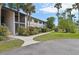 Well-maintained condo building with lush landscaping and mature palm trees at 1515 Forrest Nelson Blvd # Q205, Port Charlotte, FL 33952