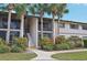 Condo building with lush landscaping, palm trees, and inviting entrance at 1515 Forrest Nelson Blvd # Q205, Port Charlotte, FL 33952