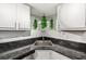 Kitchen sink area featuring a stainless steel sink, granite countertops, white cabinets and hanging plants at 1515 Forrest Nelson Blvd # Q205, Port Charlotte, FL 33952