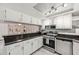 Well-equipped kitchen with stainless steel appliances and breakfast bar open to dining area at 1515 Forrest Nelson Blvd # Q205, Port Charlotte, FL 33952