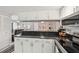Eat-in kitchen featuring white cabinets, granite countertops, and views of the living room area at 1515 Forrest Nelson Blvd # Q205, Port Charlotte, FL 33952