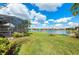 The lush green backyard extends to a serene lake, perfect for relaxation and nature views at 16741 Ellsworth Ave, Bradenton, FL 34202