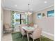 Dining room with a modern chandelier, neutral walls, and a large window overlooking the backyard and lake at 16741 Ellsworth Ave, Bradenton, FL 34202