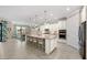 Open kitchen featuring a large island with bar seating, modern appliances, and a seamless flow into the dining area at 16741 Ellsworth Ave, Bradenton, FL 34202