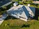 An aerial perspective of the home featuring its roof, driveway, screened patio, storage shed and manicured lawn at 222 Pine Glen Ct, Englewood, FL 34223