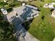 Aerial view showcasing the home's updated roof, driveway, storage shed, screened patio, and manicured landscaping at 222 Pine Glen Ct, Englewood, FL 34223