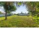 Expansive backyard view of a single-story home with well-maintained lawn and a camper in the driveway at 222 Pine Glen Ct, Englewood, FL 34223