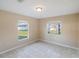 Bright bedroom featuring tile floors and two windows letting in natural light at 222 Pine Glen Ct, Englewood, FL 34223
