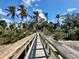 Wooden boardwalk provides a path through the mangroves toward the water with beautiful trees and plants at 222 Pine Glen Ct, Englewood, FL 34223