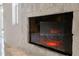 Close-up of a brick fireplace with a glass front and burning logs at 222 Pine Glen Ct, Englewood, FL 34223