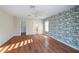 Bright main bedroom features wood floors, tropical accent wall, ceiling fan, walk-in closet and attached bath at 222 Pine Glen Ct, Englewood, FL 34223