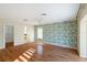 Spacious main bedroom features wood floors, tropical accent wall, ceiling fan, walk-in closet and attached bath at 222 Pine Glen Ct, Englewood, FL 34223