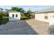 A backyard view showing a storage shed next to a patio with decorative brick and direct access to the home at 222 Pine Glen Ct, Englewood, FL 34223