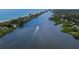 Breathtaking aerial view of a boat gliding along a tranquil waterway near a lush coastline at 222 Pine Glen Ct, Englewood, FL 34223
