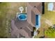 Aerial view of home featuring a fire pit, pool, well-maintained landscaping, and a brown roof at 25605 69Th E Ave, Myakka City, FL 34251