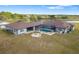 Home exterior featuring a pool, screened-in patio, fire pit, and spacious manicured lawn at 25605 69Th E Ave, Myakka City, FL 34251