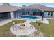 Aerial view of backyard featuring a fire pit, screened-in pool, stone pavers and well-manicured landscaping at 25605 69Th E Ave, Myakka City, FL 34251